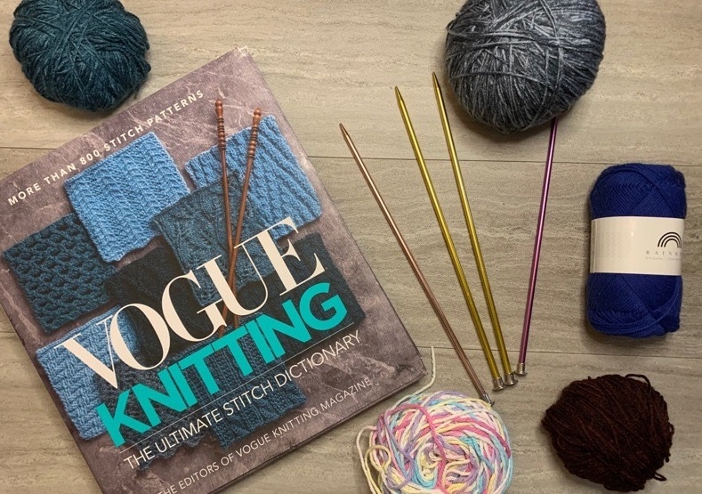 Knitting book with yarn balls and knitting needles