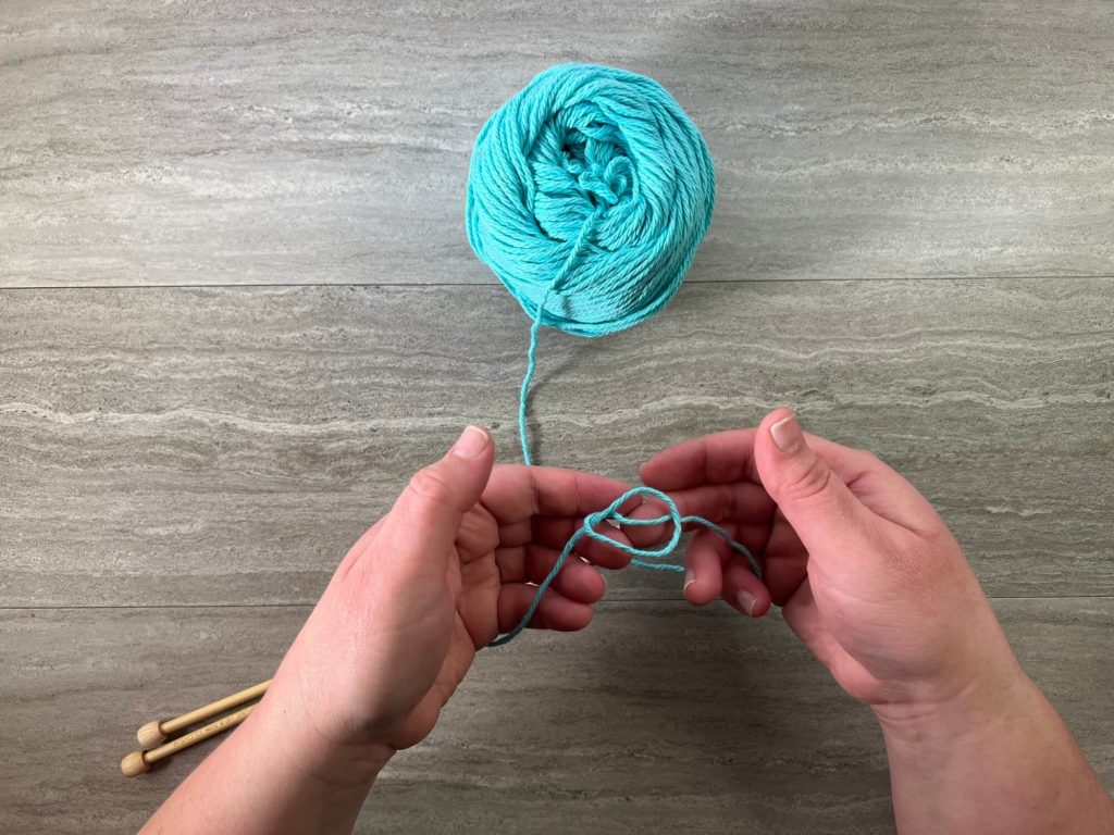 move the tail-end yarn under neath the pre-slipknot loop